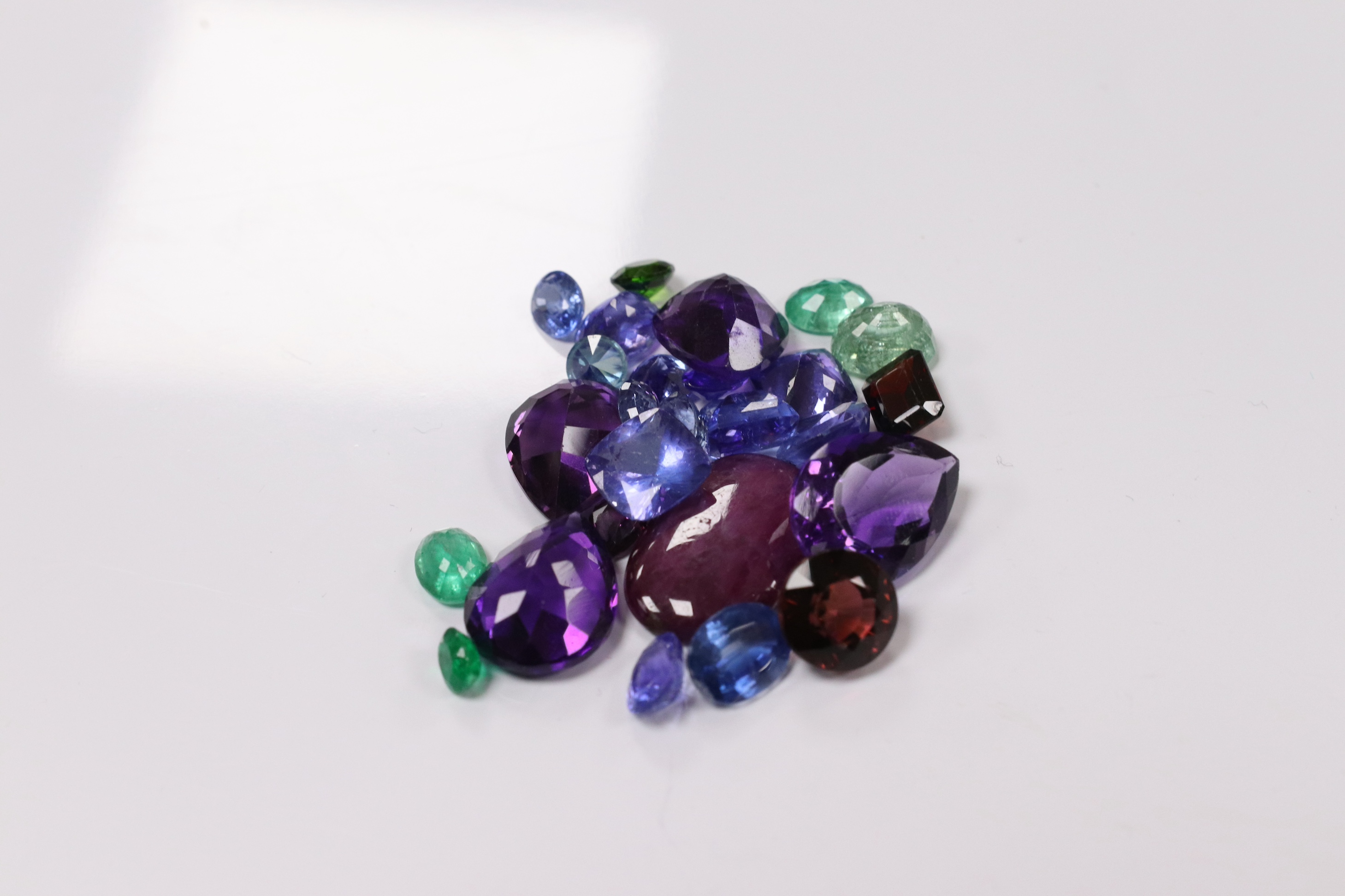 A small collection of unmounted cut gemstones, including amethyst, emerald and ruby, etc. Condition - fair